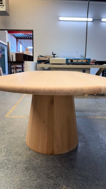Ronde houten tafel met centrale voet in de werkplaats